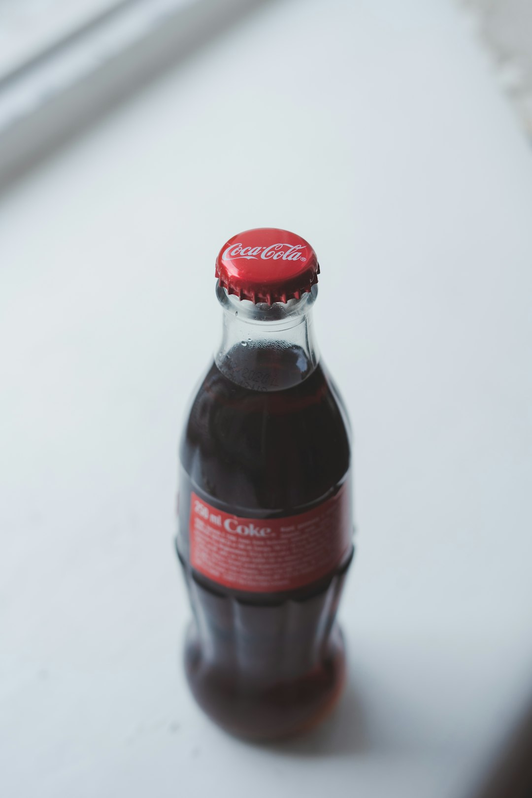 Coca-Cola bottle on white surface