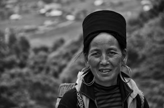 A black-and-white portrait of a woman from an indigenous community, her eyes reflecting strength and history.
