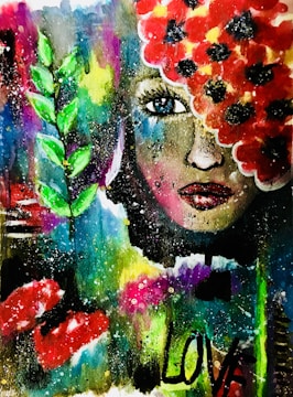 A vivid and abstract painting featuring a woman's face partially covered with bright red flowers. Her expressive blue eye stands out, surrounded by vibrant colors including green leaves to the side. The word 'LOVE' is painted in bold black letters on the lower part of the image, with splashes and dots of various colors scattered throughout the background.