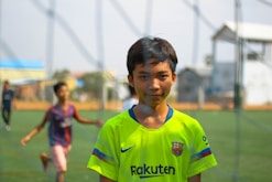 Young footballers training intensely on a lush Barcelona pitch under clear skies.