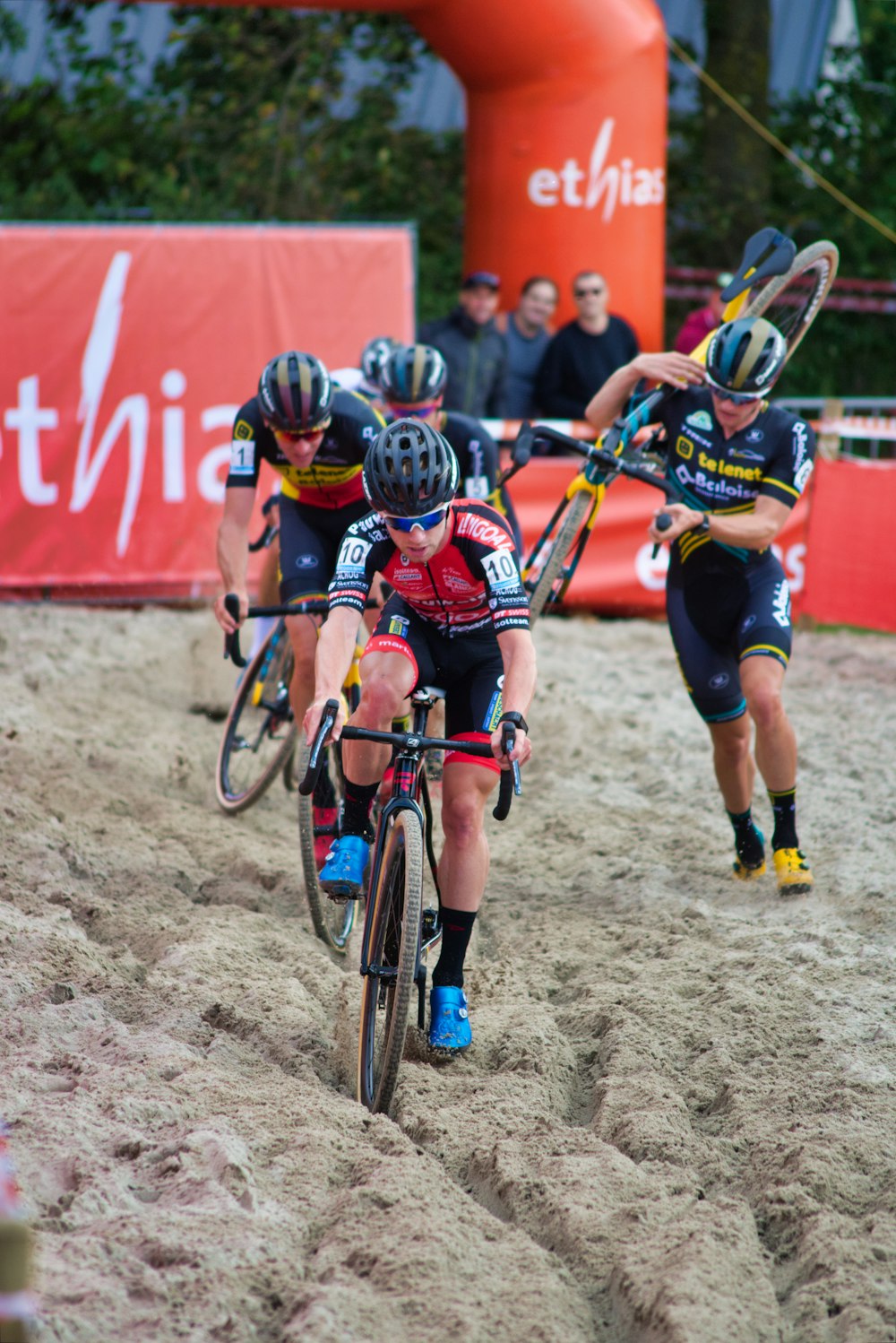a group of people riding bikes on top of a dirt field