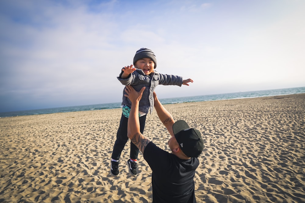 man carries the boy near seashore