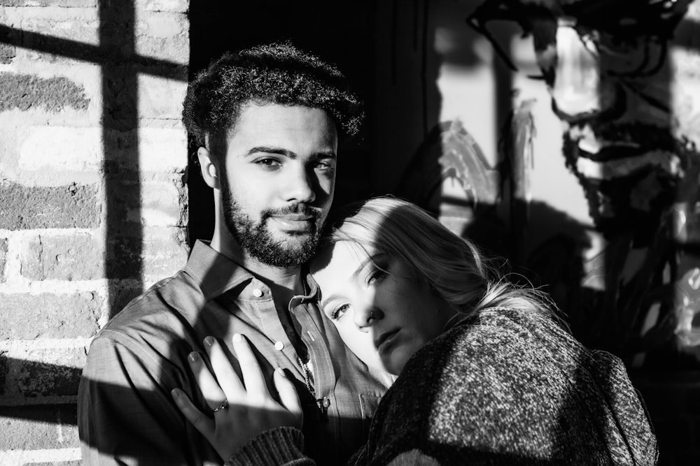 grayscale photography of woman leaning on body of man