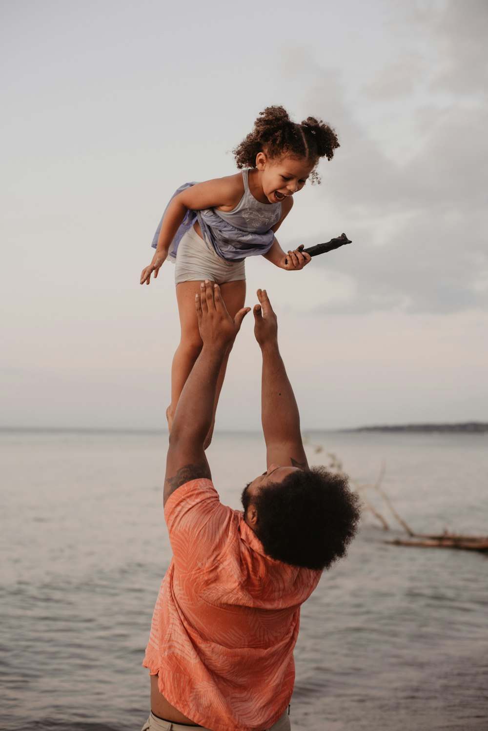 man in pink shirt lifting up girl