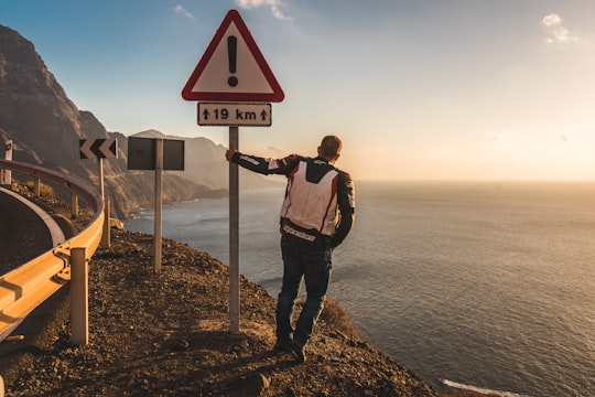 man standing on street signage in Gran Canaria Spain