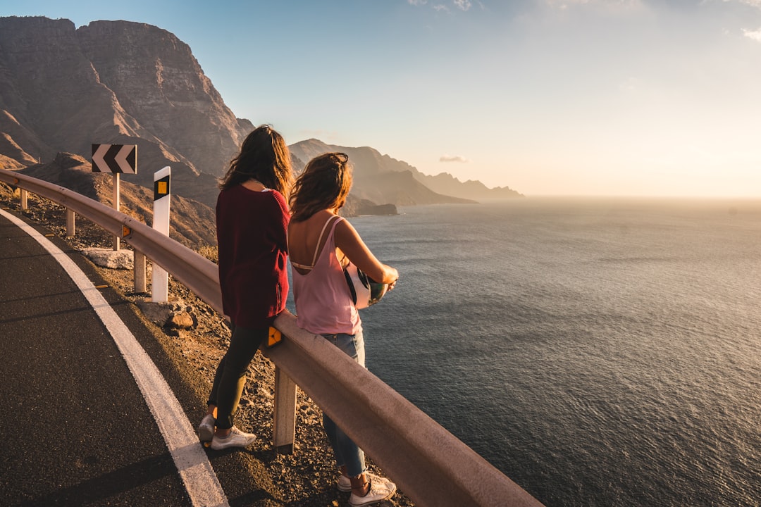 two women standing on fence