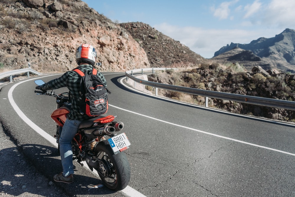 Homem andando de moto perto da rodovia