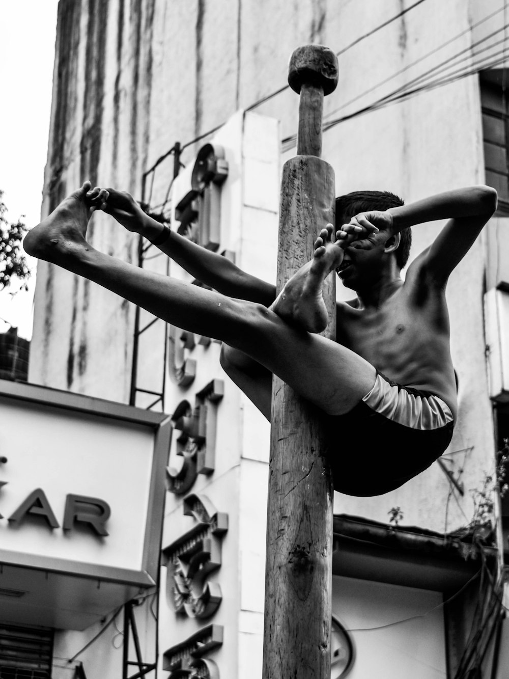 a man is doing a hand stand on a pole