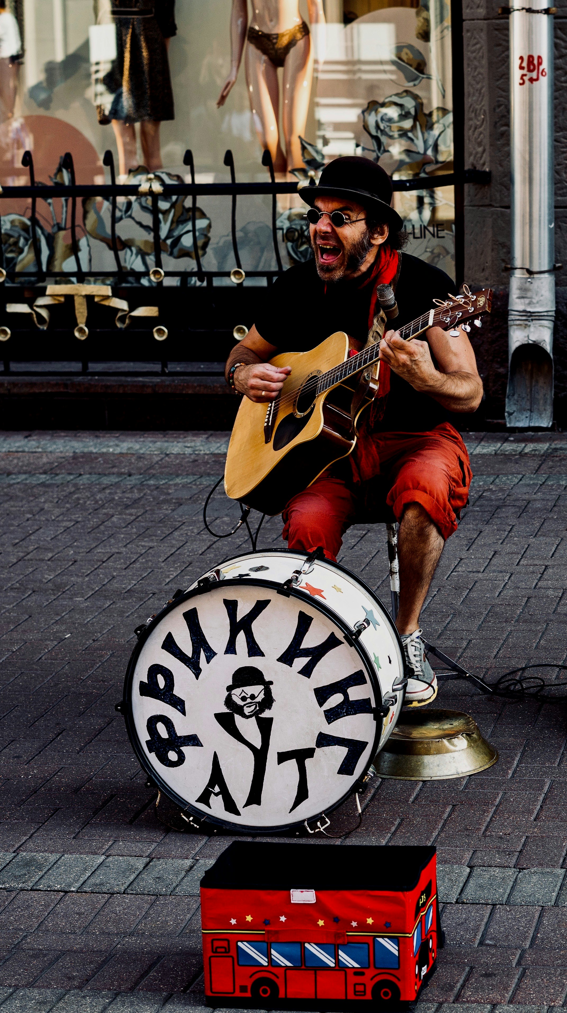 man playing guitar in front of snare drum