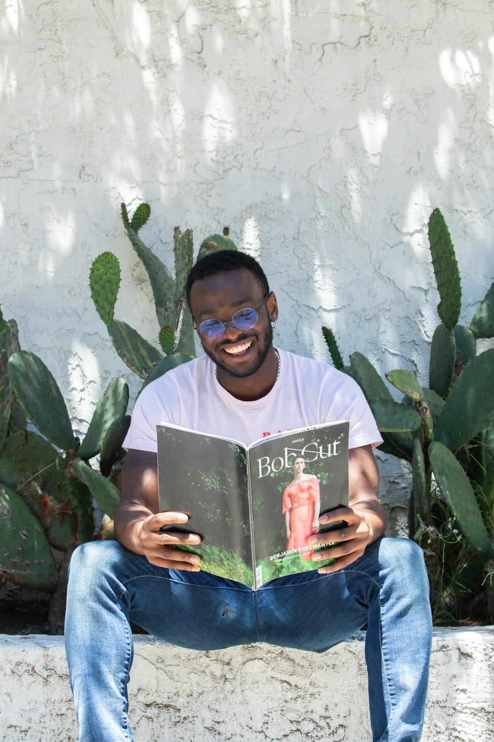 man in white crew-neck T-shirt reading book