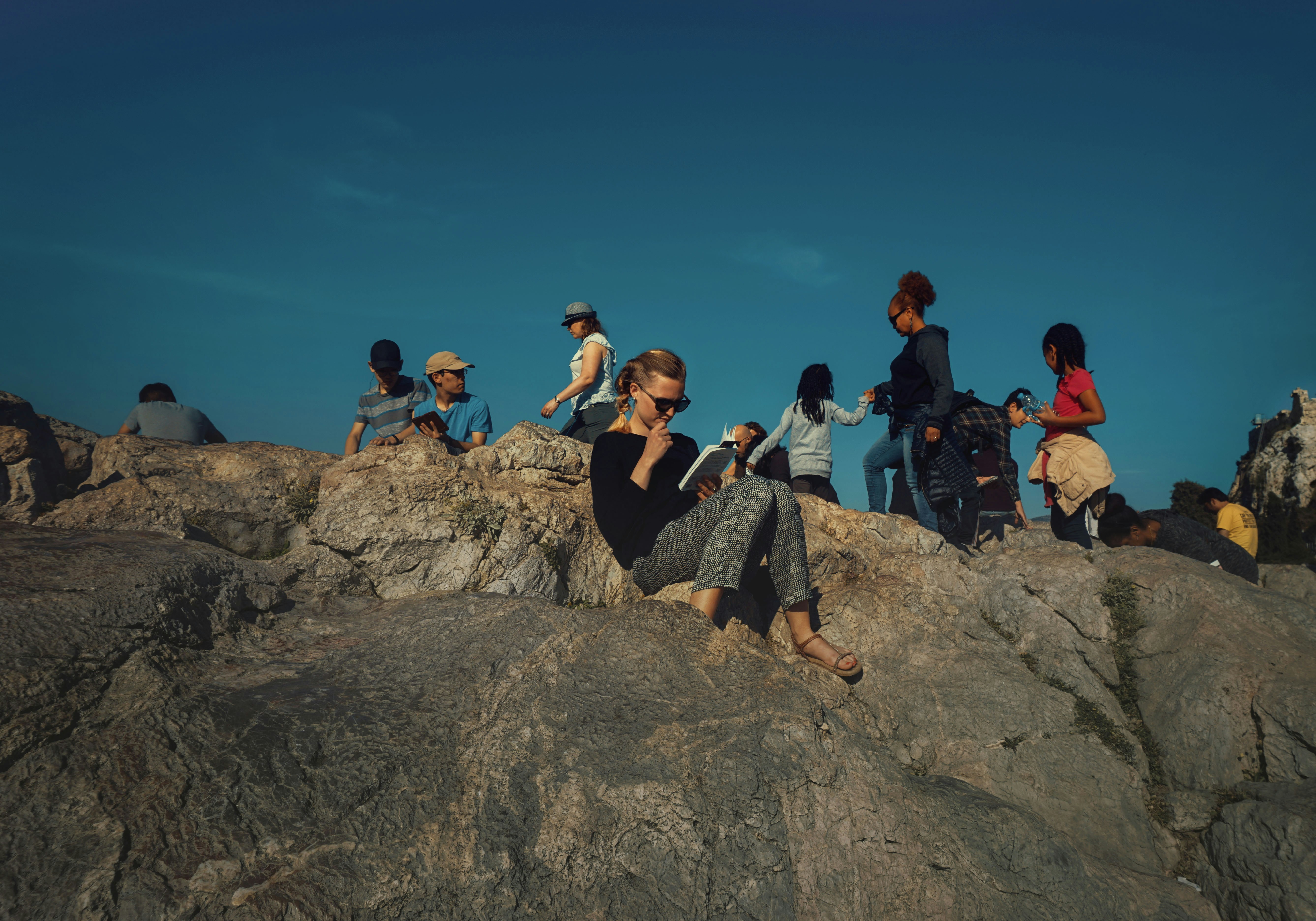 Tourist reading a book on the top of a hill in Athens