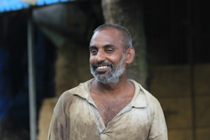 Portrait of a friendly middle-aged man in a handyman uniform, smiling confidently.