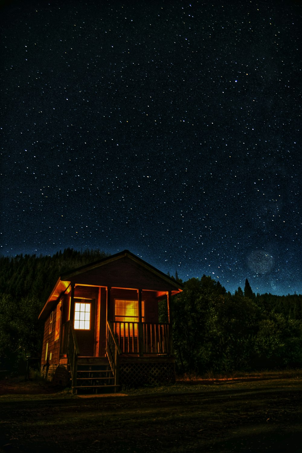 a cabin at night with the stars in the sky