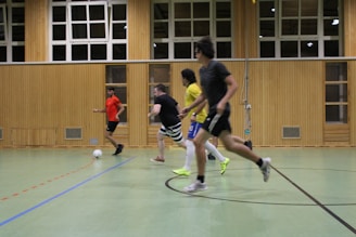 A vibrant indoor soccer match in action with players focused on the game.