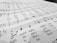 A close-up view of a sheet of music with musical notes and lyrics printed in black ink on a white background. The focus is on the lower part, where the notes and the words 'wake my spirit' and 'perish' are visible.