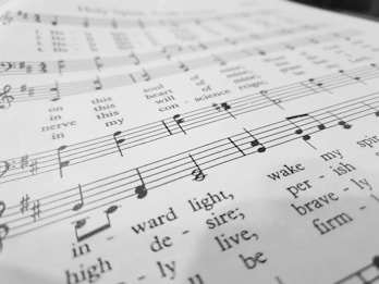 A close-up view of a sheet of music with musical notes and lyrics printed in black ink on a white background. The focus is on the lower part, where the notes and the words 'wake my spirit' and 'perish' are visible.