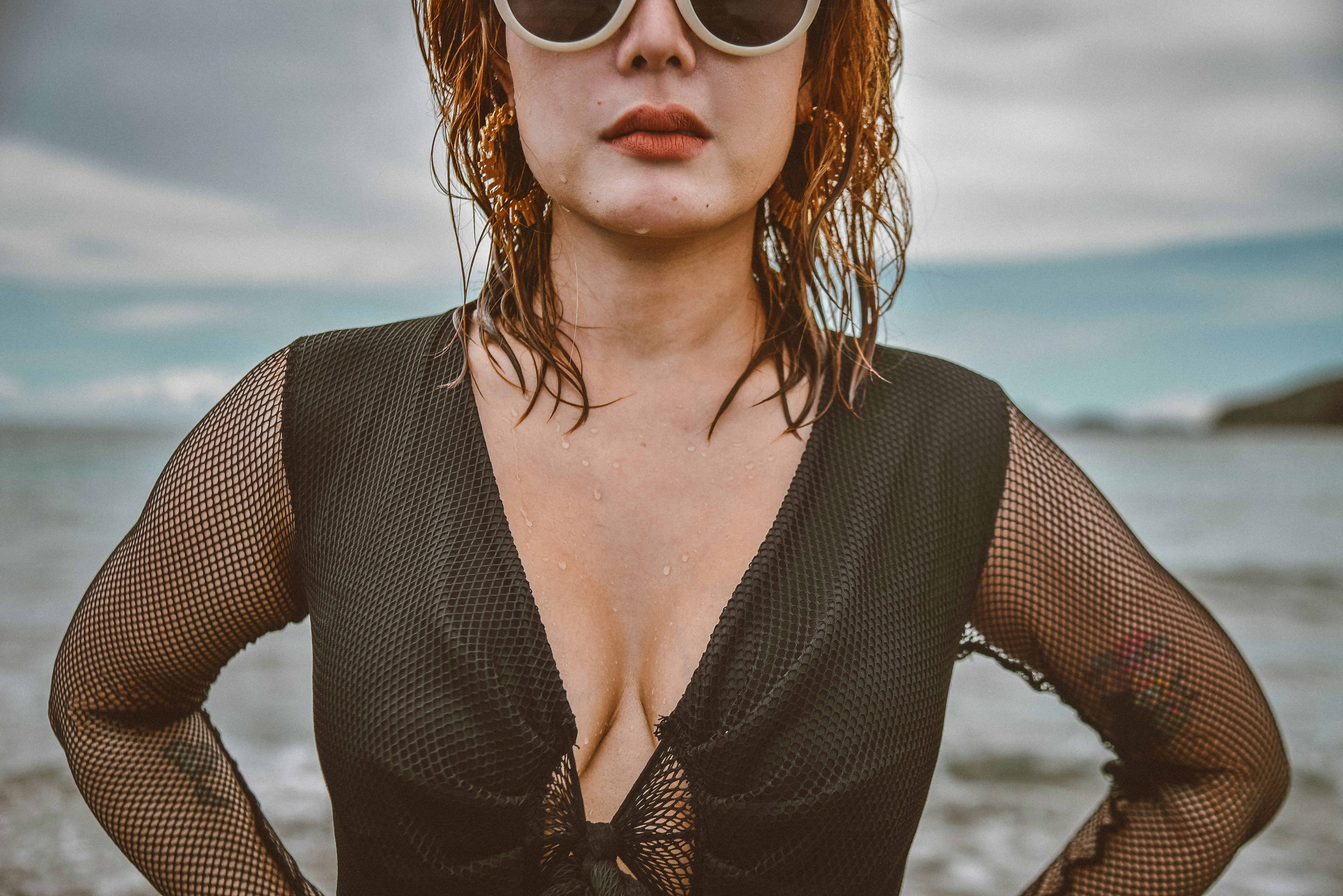 Woman wearing a long-sleeve fishnet body stocking with a scoop neckline - Fishnet body stockings