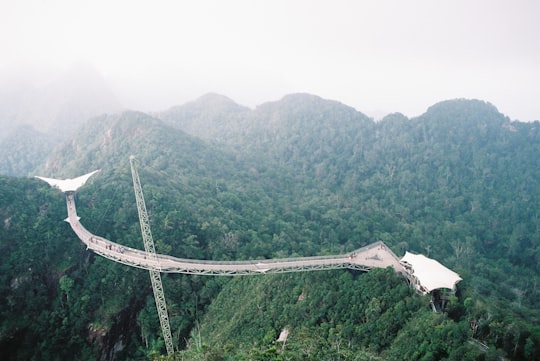 aerial photography of a bridge over the mountain in Temurun Waterfall Malaysia
