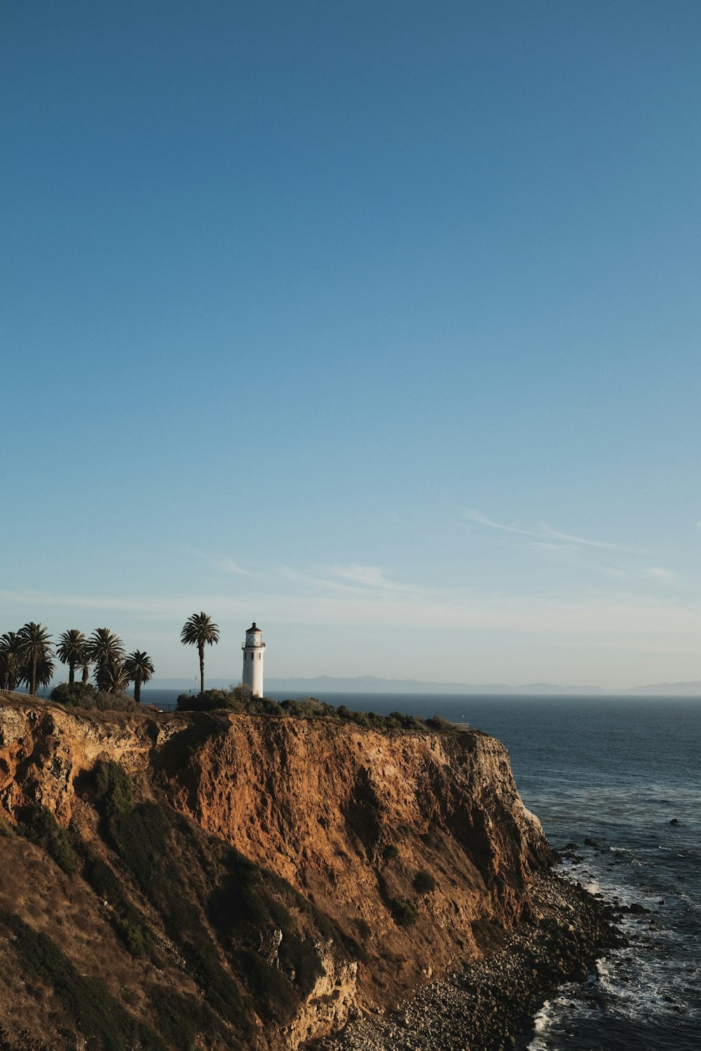 white lighthouse on cliff