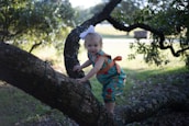 Smiling child wearing a lilare outfit and a matching bow in a sunny park.