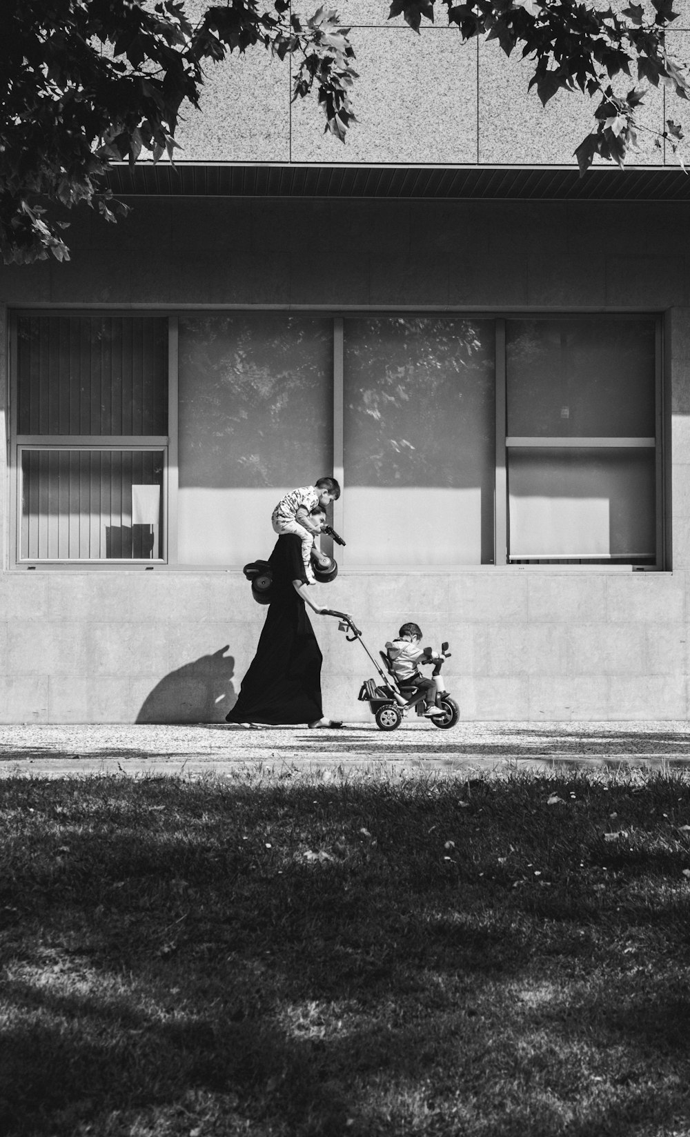 grayscale photo of woman pushing stroller