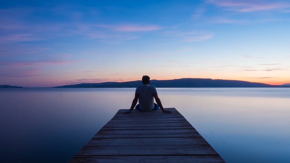 man siting on wooden dock