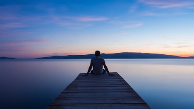 man siting on wooden dock peaceful google meet background