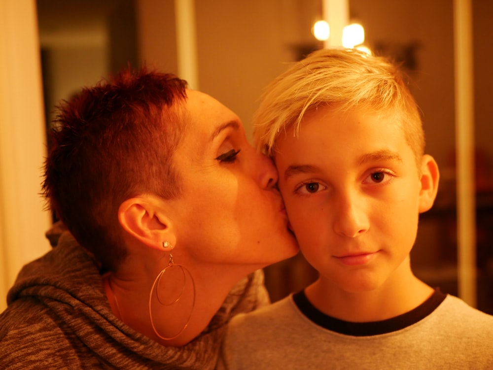 woman kissing boy's cheek