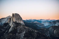 Sunset view from Half Dome in Yosemite, with climbers silhouetted against the sky.