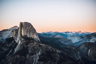 Sunset view from Half Dome in Yosemite, with climbers silhouetted against the sky.