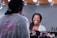 A smiling woman admiring her reflection in a mirror after a cosmetic treatment.