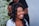 A smiling woman with styled hair enjoying a salon experience.