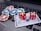 A set of red dice and poker chips are placed on top of a credit card, which is situated on a laptop keyboard. The poker chips are in various colors, including blue, green, red, and white.
