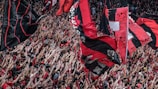 Fans waving flags and wearing team colors.