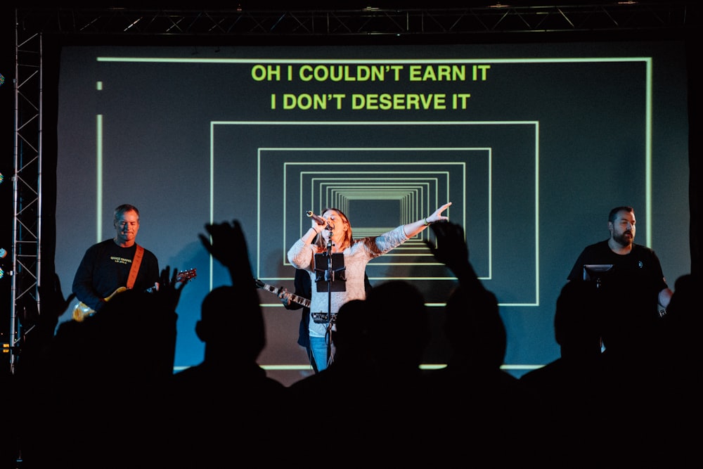 woman wearing gray long-sleeved shirt performing on stage