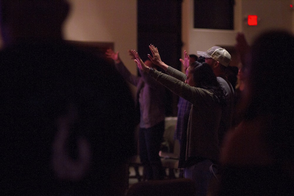 a group of people standing in a room with their hands up