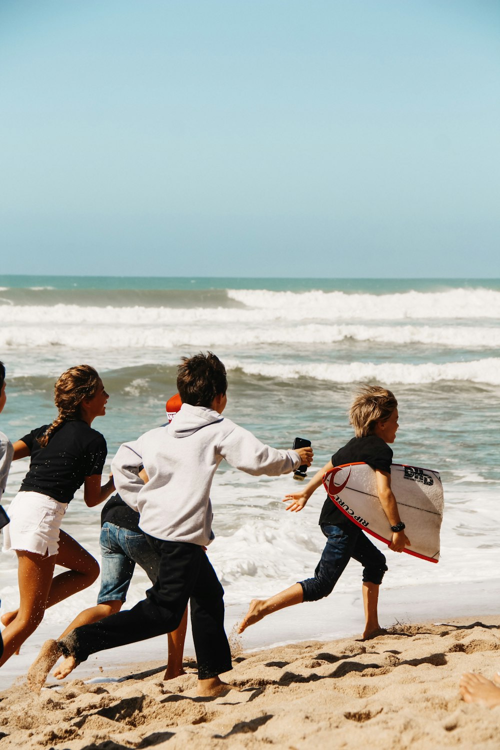 children running on seashore across horizon