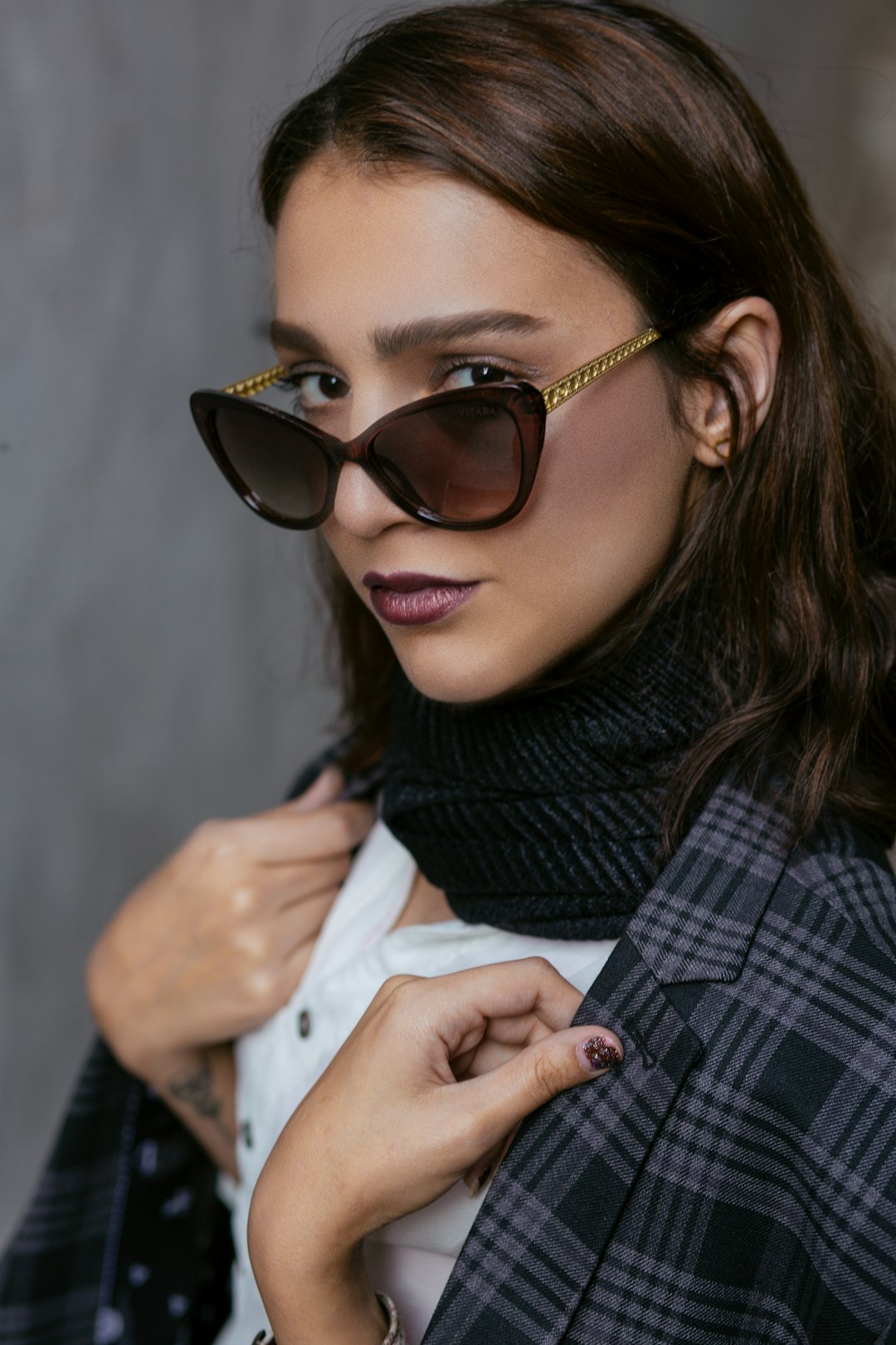 woman in black and gray scarf wearing black framed sunglasses