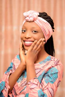 A smiling person draped in soft pastel colours, highlighting their natural glow.