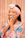 A smiling woman wearing a soft blush satin bonnet, glowing with confidence