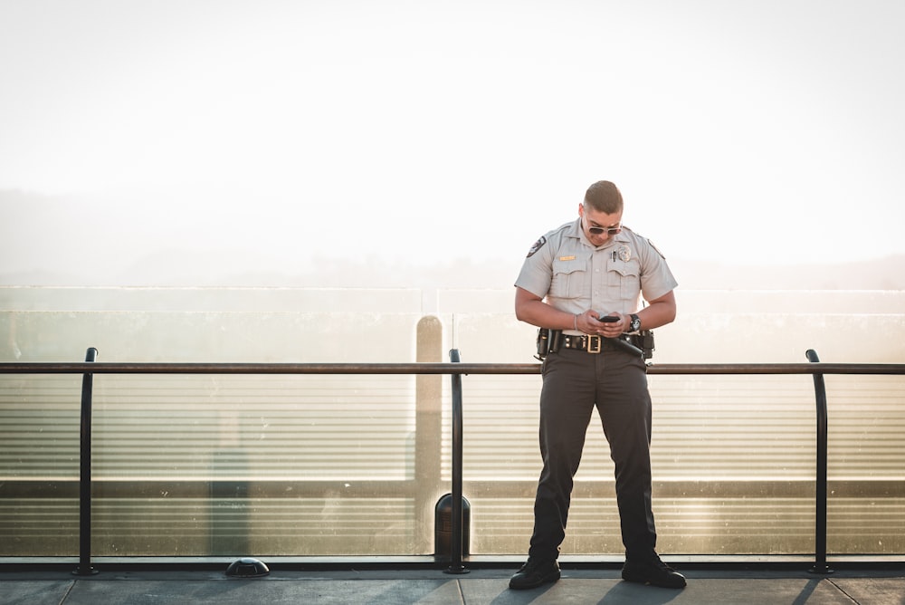 poliziotto appoggiato su binario metallico durante una giornata di sole