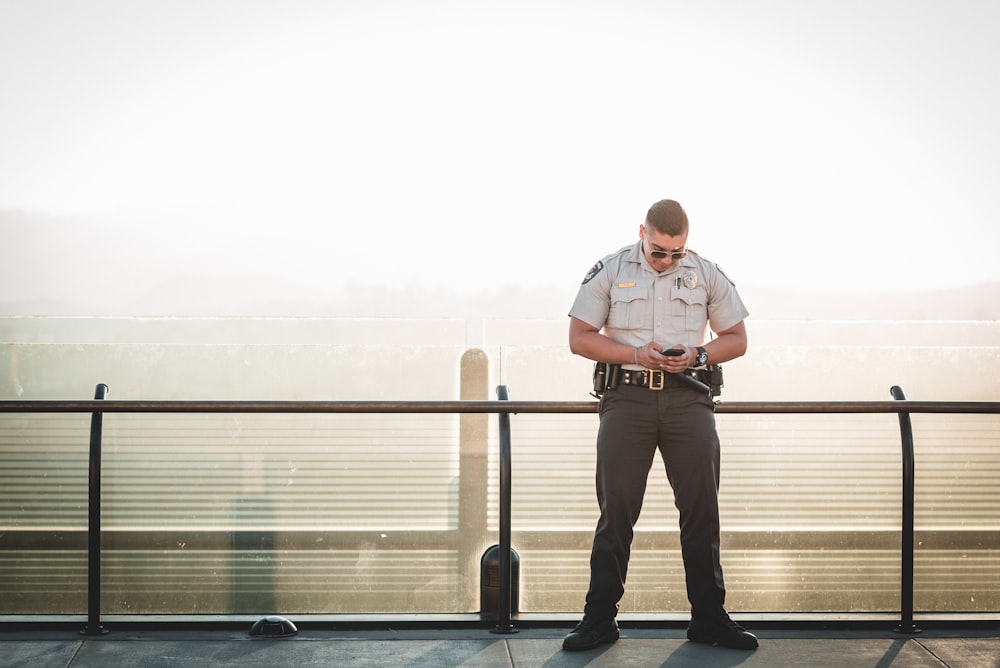 Polizist lehnt sich an einem sonnigen Tag an Metallschiene