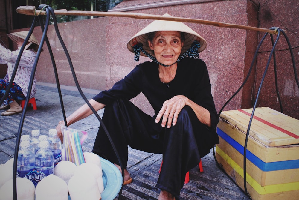 Mujer sentada en un taburete cerca de la pared