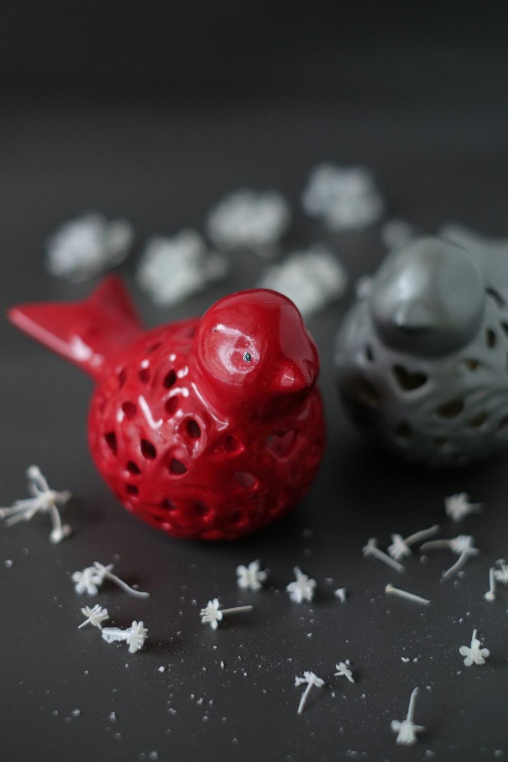 two gray and red bird figurines on gray surface