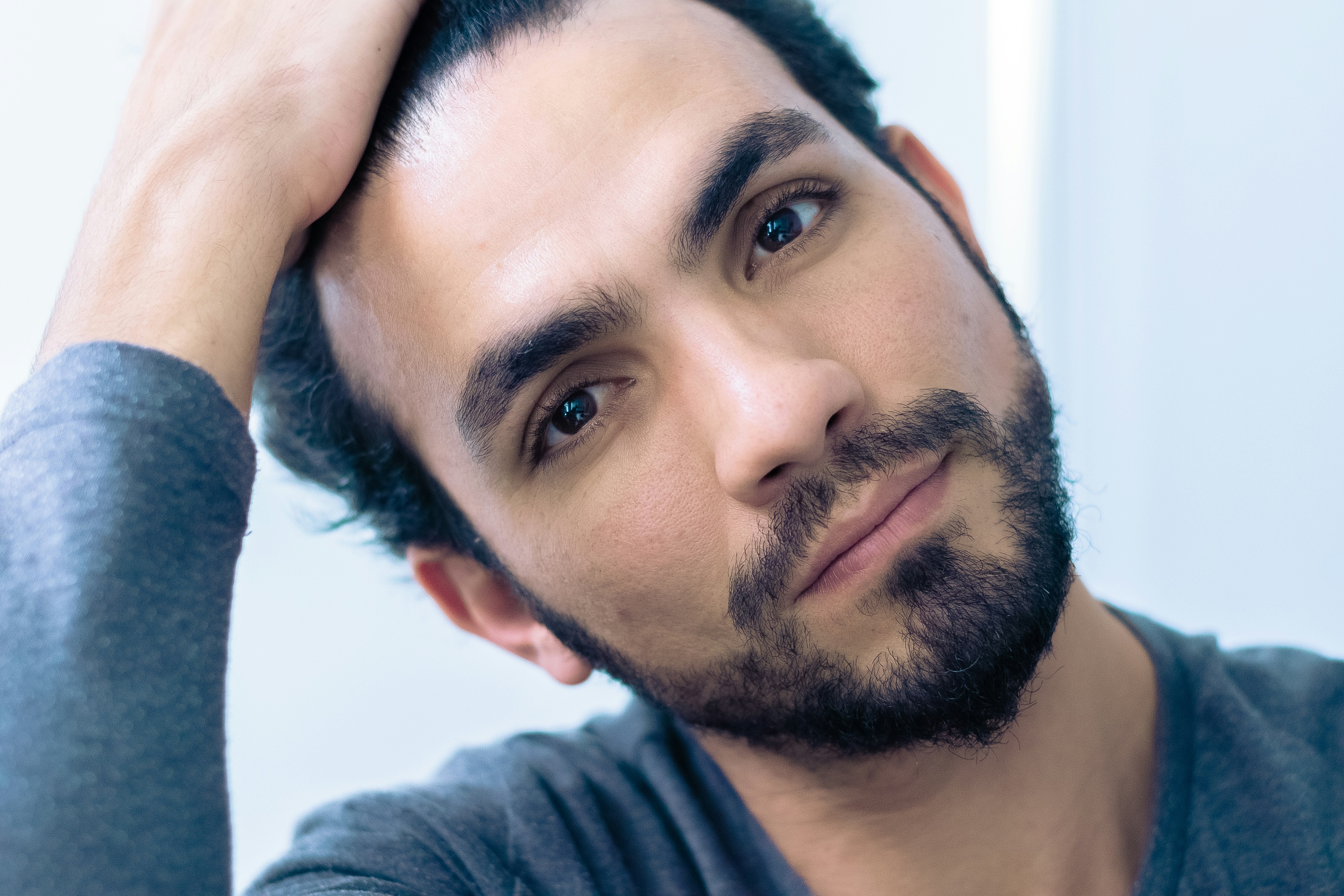 portrait of man wearing gray crew-neck long-sleeved shirt