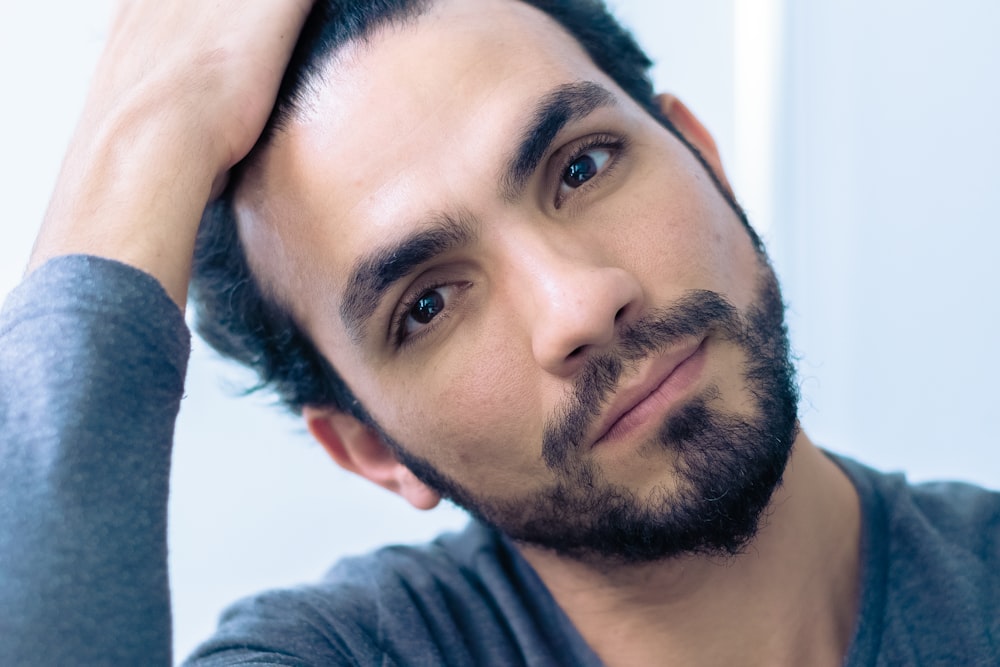 portrait of man wearing gray crew-neck long-sleeved shirt