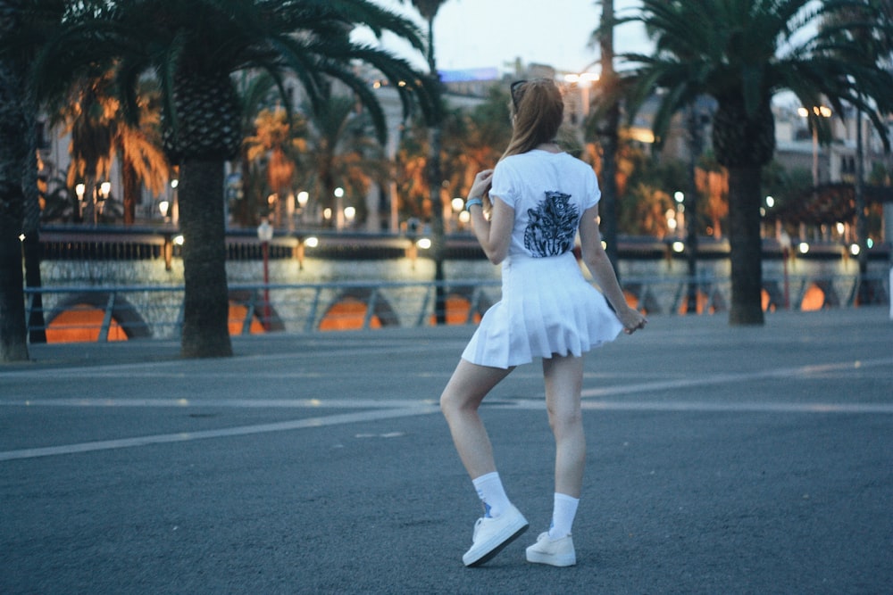 woman wearing white mini skirt standing on concrete surface