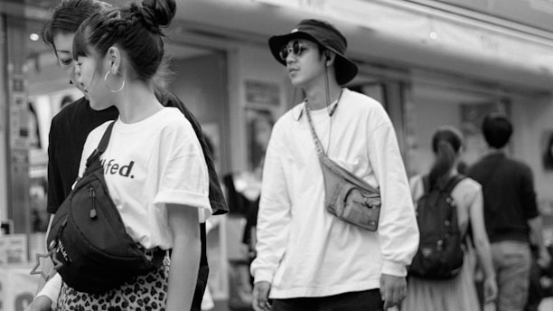 A trendy urban scene featuring a model carrying a sleek mavique london bag and wearing slides.