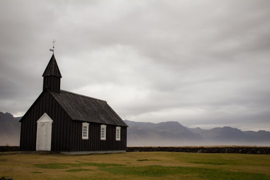 black church on plains during daytime in Búðakirkja Iceland