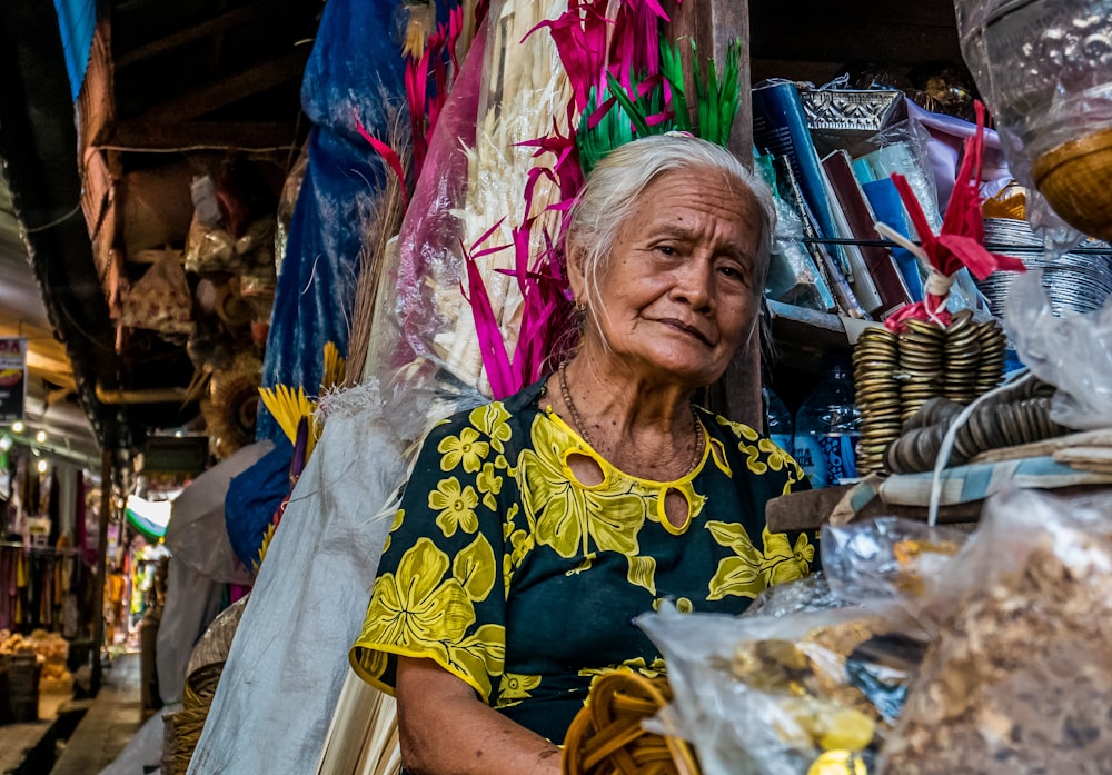Frau trägt grün-gelbes Kleid und verkauft Waren
